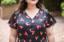 Load image into Gallery viewer, close up of plus size black and red heart print v neck satin blouse with peplum