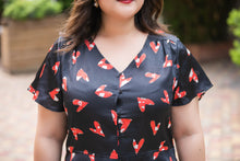 Load image into Gallery viewer, close up of plus size black and red heart print v neck satin blouse with peplum
