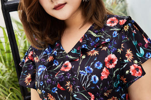 close up of Plus size black floral print faux wrap dress with ruffles